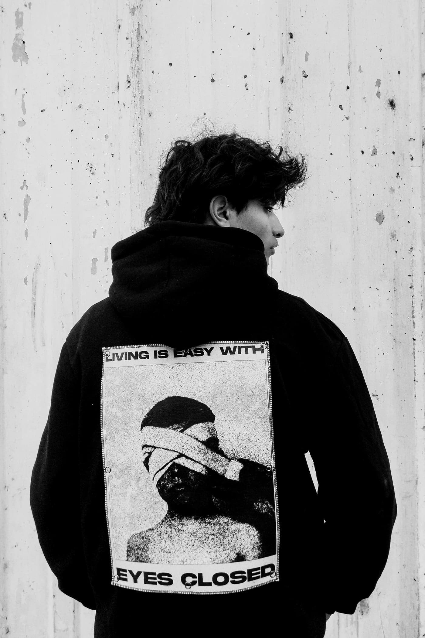 Model in an oversized black hoodie, seen from behind